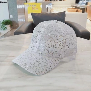 Detail of silver sequined baseball cap with breathable mesh fabric on marble surface