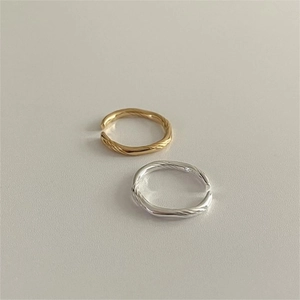 Detail shot of 925 sterling silver twisted wave open rings in gold and silver finish