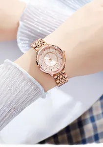 Détail du cadran de montre or rose serti de cristaux de luxe et bracelet métallique