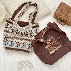 Detail of reversible plush tote bag featuring ethnic patterns and solid brown fabric