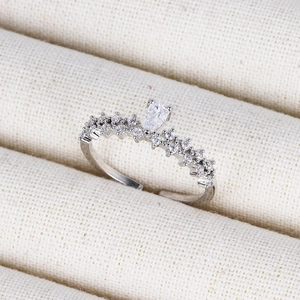 Detailed close-up of a silver crown ring with a pear-shaped zircon on a jewelry display