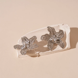Macro shot of silver zircon flower earrings with marquise stones on a plaster base