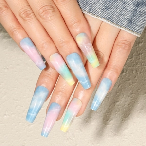 Detail of long press-on nails featuring blue pink yellow marble clouds and glossy finish