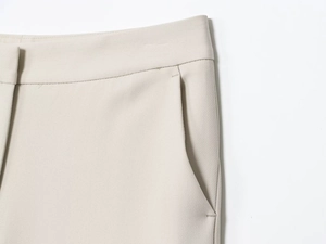 Gros plan détaillé du pantalon de costume beige clair avec ceinture et coutures de poche