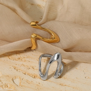 Minimalist irregular fluid shape rings in gold and silver finish on textured stone background