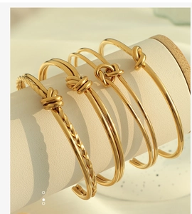 Dettaglio macro di bracciali aperti a nodo in oro retrò francese su supporto gioielli