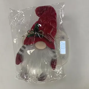 Christmas gnome plush toy on a digital scale showing weight 100.2g for shipping