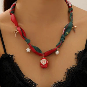 Gros plan d'un collier festif en corde rouge et verte avec un pendentif Père Noël