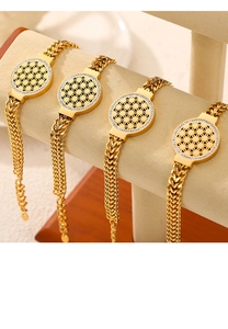 Détail de quatre bracelets dorés avec pendentifs floraux et cristaux sur un présentoir