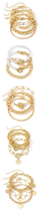 Cinq sets de bracelets dorés superposés avec chaînes épaisses, perles et cœurs