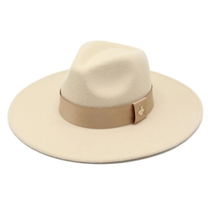 Detail of beige felt fedora hat featuring a tan ribbon and gold bee metal buckle