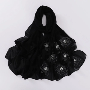Detail of black chiffon hijab scarf with silver beadwork and rhinestone flower patterns