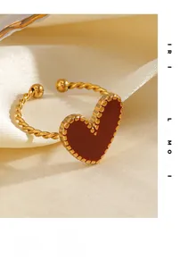 Detail of red heart ring with gold twisted band on elegant beige satin fabric
