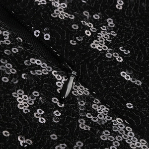 Detailed view of black sequins and concealed zipper on a sexy slit evening dress