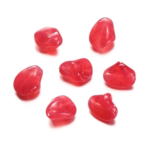 Detail of red irregular acrylic beads with white swirl patterns for DIY crafts