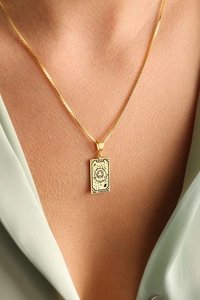 Detail of 18K gold tarot necklace showing the Strength card with lion on a box chain