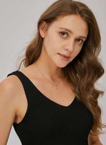 Detail of minimalist gold chain necklace with a single round zircon on a model