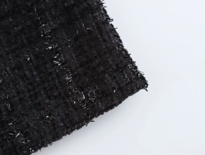 Vue macro détaillée du tissu en tweed noir avec tissage de fils métalliques argentés