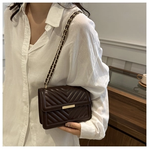 Detail of dark brown quilted V-pattern crossbody bag with gold chain and square lock