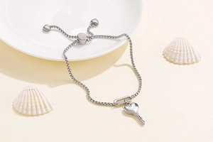 Détail du pendentif clé cœur en argent sur chaîne réglable avec décor de coquillages