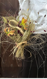 Natural raffia grass bouquet with flame lily and calla lily for floral gift wrapping