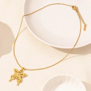 Detail of gold butterfly pendant with O-chain and lobster clasp on stainless steel necklace