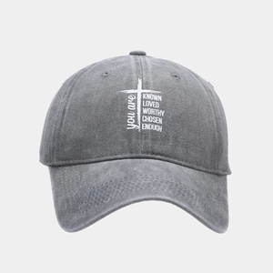 Close-up of washed cotton baseball cap featuring inspirational text and cross graphic