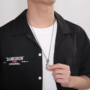 Silver stainless steel necklace with a unique fishhook pendant worn on a male model