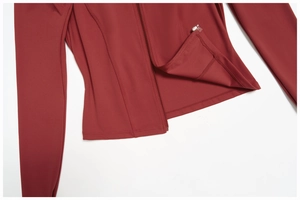 Detailaufnahme von Reißverschluss und Nähten einer eng anliegenden dunkelroten Yoga-Jacke