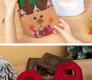 Detail of Christmas reindeer felt gift bags with red plaid and Santa Claus motifs