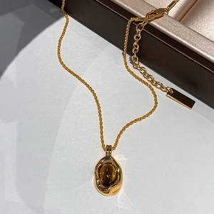 Gold plated oval tiger eye stone necklace and earrings set displayed on a jewelry box
