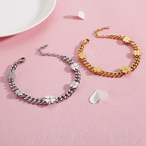 Lucky clover charm bracelets in gold and silver finish with crystal center on pink surface