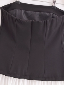 Detail of the invisible back zipper on a strapless black and white midi dress