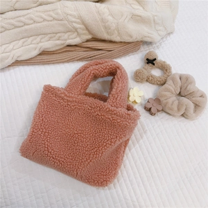 Détail du sac à main en laine d'agneau rose avec ours en peluche et accessoires fleuris