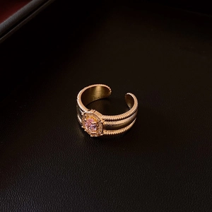 Détail d'une bague ouverte dorée multicouche avec pierre ovale rose et pavé scintillant