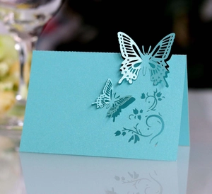 Close-up of laser-cut butterfly wedding place cards in pearl light blue cardstock