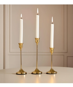 Polished gold candle holders with slim stems and non-slip bases in three varying heights