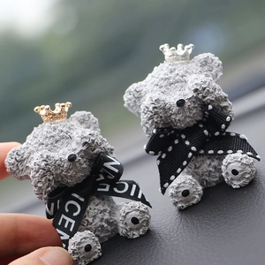 Close-up of grey teddy bear car air vent clips with gold and silver crowns
