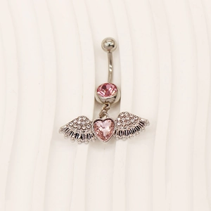 Detailed view of silver navel ring with pink heart zircon and wings on beige background