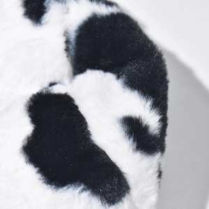 Faux fur bucket hat with black and white cow print texture and soft plush material