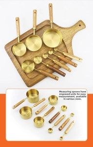 Detail of stainless steel measuring cups with acacia wood handles and engraved units
