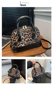 Detail of leopard print shell bag with black leather trim and golden metal hardware