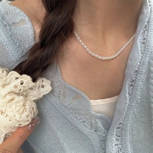 Elegant French vintage style pearl necklace featuring oval beads on a model's neck