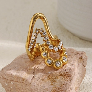 Close-up of 18K gold-plated multi-layer wave ring with zircons on natural stone