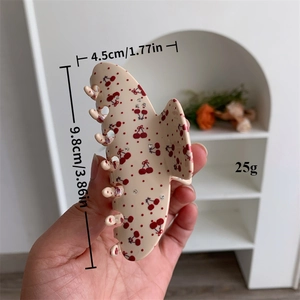 Detail showing the 9.8cm cherry pattern acetate hair claw clip with size and weight metrics