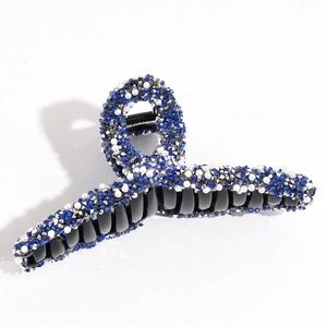 Detailed view of the large blue rhinestone and pearl hair claw clip for thick hair.