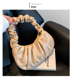 Detail view of khaki pleated cloud bag showing soft PU leather texture and ruched strap