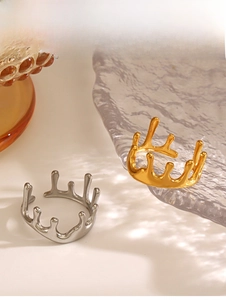 Detail of irregular 18K gold and silver plated lava rings on luxury glass background