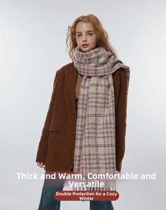 Close-up of thick checkered scarf with fringes paired with a brown corduroy jacket