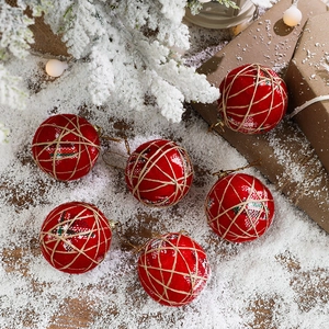 Set of 6 red fabric Christmas balls with twine wrap on snow background